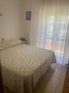 - une chambre avec un lit et une fenêtre avec des rideaux dans l'établissement Casa Limone, à Petacciato