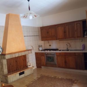 a kitchen with wooden cabinets and a stove top oven at Casa Limone in Petacciato