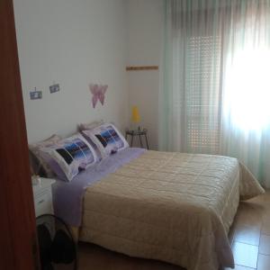 - une chambre avec un grand lit et une fenêtre dans l'établissement Casa Limone, à Petacciato