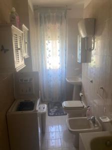 La petite salle de bains est pourvue de toilettes et d'un lavabo. dans l'établissement Casa Limone, à Petacciato