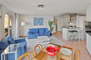 ein Wohnzimmer mit einem blauen Sofa und einem Tisch in der Unterkunft Splendide logement avec vue plongeante sur le lac in Saint-Gingolph