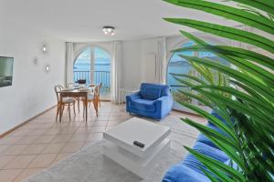 a living room with a blue couch and a table at Splendide logement avec vue plongeante sur le lac in Saint-Gingolph