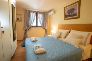 1 dormitorio con 1 cama azul y 2 toallas en Appartamento in Casa Olea, en SantʼAndrea
