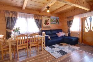 sala de estar con sofá azul y mesa en Domki i Apartamenty Krupa Ciche, en Zakopane