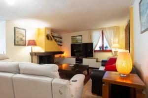 sala de estar con sofá blanco y chimenea en Appartamento in Casa Olea, en SantʼAndrea