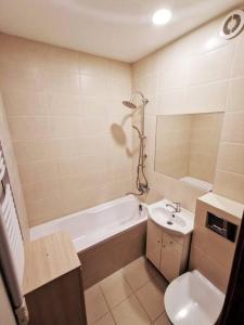 a bathroom with a tub and a toilet and a sink at Apartament near Kaunas Castle in Kaunas