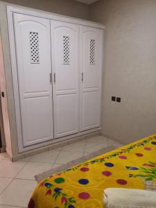 1 dormitorio con armarios blancos y manta amarilla en Stone house, en Mirleft