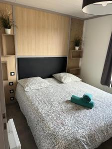 a bedroom with a bed with a blue towel on it at Cottage parc résidentiel de loisir in Saubrigues