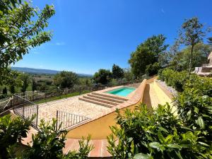 a swimming pool with stairs next to a resort at B&B Cantico Delle Creature in Assisi