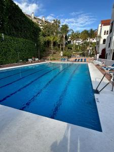 une grande piscine d'eau bleue dans l'établissement Enjoy Spain - La Maestranza, à Marbella