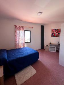 Un dormitorio con una cama azul y una ventana. en BrisaMarTelde, en Telde
