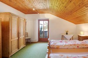 a bedroom with two beds and a wooden ceiling at Pitschlhof Apt Lärche in Aldino