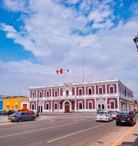 un edificio rosa con una bandera canadiense encima en Hostal Solari, en Trujillo