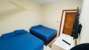 Habitación pequeña con 2 camas y TV. en Departamento Zuatynky en Asunción