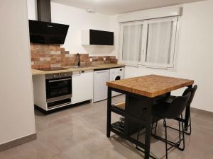 eine Küche mit einem Holztisch und einer Arbeitsplatte in der Unterkunft Appart43m² Proche Gare et Centre in Cholet