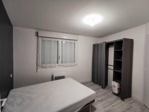 ein Schlafzimmer mit einem weißen Bett und einem Fenster in der Unterkunft Appart43m² Proche Gare et Centre in Cholet