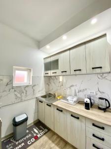 una cucina con armadi bianchi e ripiani in marmo di Orachovac apartments a Kotor (Cattaro)