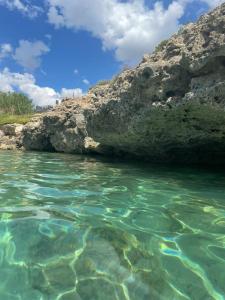una piscina de agua junto a una orilla rocosa en B&B Baia Del Salento, en Pulsano