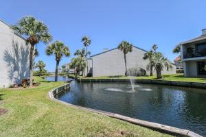 einen Brunnen in einem Teich im Garten mit Palmen in der Unterkunft Sea Winds 26 in St. Augustine