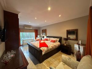 a bedroom with a bed with a red pillow on it at ARK Guesthouse in Potchefstroom