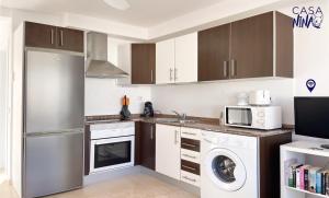 a kitchen with a washer and dryer and a microwave at Los Delfines Casa Nina by Rentalfue in Corralejo