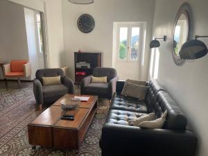 a living room with a leather couch and a coffee table at Maison de village Cévenole climatisée à Branoux-Les-Taillades - Gard - #TravellerAwards 2025 in Branoux-les-Taillades