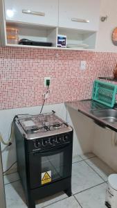 a stove in a kitchen with a counter and a sink at Charmoso Flat Funcional No PAPICU Próximo AO SHOPPING RIO MAR in Fortaleza