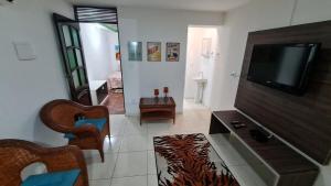 a living room with a flat screen tv and a couch at Charmoso Flat Funcional No PAPICU Próximo AO SHOPPING RIO MAR in Fortaleza
