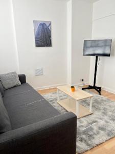 a living room with a couch and a table at 2 bedroom near Euston, King's Cross in London