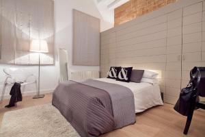 a bedroom with a bed and a brick wall at Cathedral Apartment in Barcelona