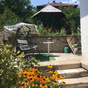 una sedia e un ombrellone in un giardino fiorito di Vila Venera a Velingrad