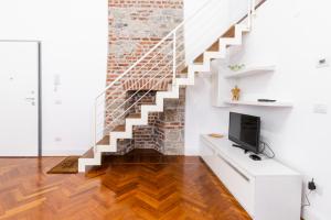 uma sala de estar com uma escada e uma televisão em Loft via morosini centro Varese - IXIHOME em Varese