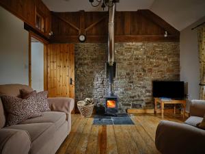 a living room with a stone wall and a fireplace at Linhay, Pattard in Hartland