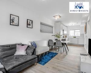 ein Wohnzimmer mit einem Sofa und einem Tisch in der Unterkunft Modern And Stylish Two Bedroom Apartments by Direct2hosts With Great Location! in London
