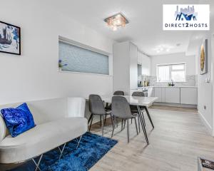 salon z białą kanapą i stołem w obiekcie Modern And Stylish Two Bedroom Apartments by Direct2hosts With Great Location! w Londynie