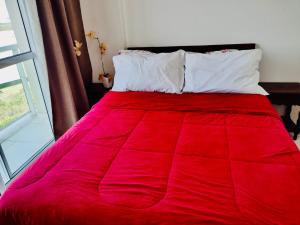 Cama roja con almohadas blancas y manta roja en Rio Stay Suíte en Río de Janeiro