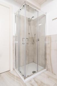 La salle de bains est pourvue d'une douche et d'une cabine de verre. dans l'établissement Loft via morosini centro Varese - IXIHOME, à Varèse