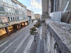 Une rue vide avec quelques plantes sur le côté d'un bâtiment dans l'établissement Loft via morosini centro Varese - IXIHOME, à Varèse