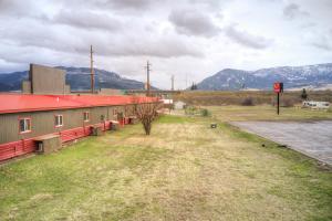 a building with a red roof next to a field at Livingston Inn - Historic in Livingston +4 photos