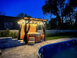 a gazebo with a hot tub in a backyard at Black Horse in Pasłęk