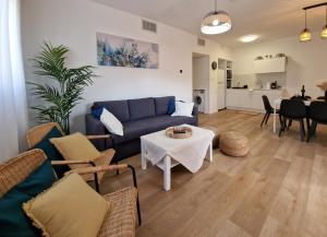 - un salon avec un canapé bleu et une table dans l'établissement מאנטה manta דירת נופש באילת, à Eilat