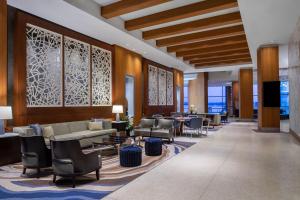 ナショナルハーバーにあるThe Westin Washington National Harborのソファ、椅子、薄型テレビが備わるロビー