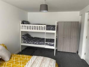 a bedroom with two bunk beds and a closet at Lovely stylish apartment with breathtaking views. in Llanddulas