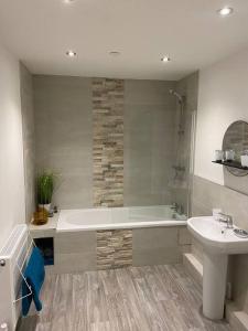 a bathroom with a bath tub and a sink at Lovely stylish apartment with breathtaking views. in Llanddulas