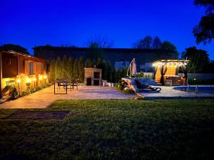 a backyard at night with a house with lights at Black Horse in Pasłęk
