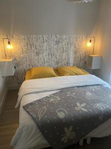 sypialnia z łóżkiem z dwoma lampami na ścianie w obiekcie Oxalis w mieście Bagnères-de-Bigorre