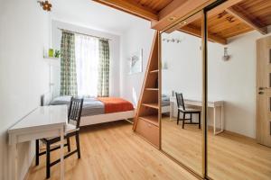 a bedroom with a bed and a desk and a table at Rooms in City Center in Gdańsk