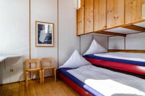 a bedroom with two bunk beds and a chair at Adlerhorst über dem Bodensee in Sipplingen