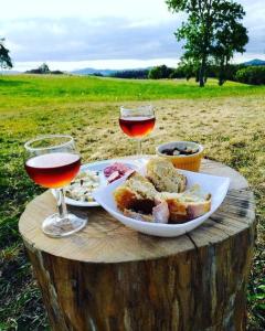 een tafel met een bord eten en twee glazen wijn bij Grand Gîte Confortable en Auvergne - Belle vue in Brousse
