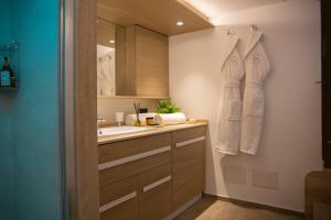 a bathroom with a sink and a mirror at Meravigghia Suites Cefalù in Cefalù +74 photos